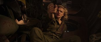 Movie still from “Shadow in the Cloud” (2020), directed by Roseanne Liang – A person holding a gun in a room; Medium shot, Low angle