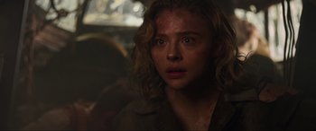 Movie still from “Shadow in the Cloud” (2020), directed by Roseanne Liang – A person with curly blonde hair; Close Up shot, Over the shoulder angle