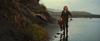 Movie still from “Shadow in the Cloud” (2020), directed by Roseanne Liang – A woman walking across a body of water holding a bag; Wide shot, Low angle
