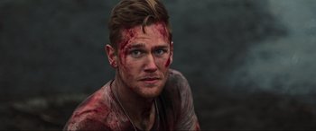 Movie still from “Shadow in the Cloud” (2020), directed by Roseanne Liang – A man with blood all over his face and chest; Close Up shot, Over the shoulder angle