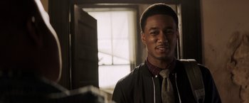 Movie still from “Shaft” (2019), directed by Tim Story – A man in a jacket and tie in a dimly lit room; Close Up shot, Over the shoulder angle