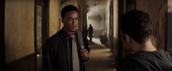 Movie still from “Shaft” (2019), directed by Tim Story – A man in a hallway with a tie and jacket on; Medium shot, Over the shoulder angle
