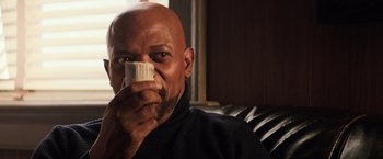 Movie still from “Shaft” (2019), directed by Tim Story – A bald man drinking a cup of coffee; Close Up shot, Low angle