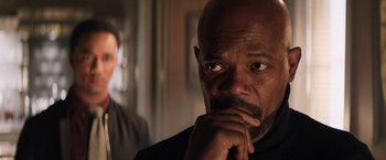Movie still from “Shaft” (2019), directed by Tim Story – An older man with his hand under his chin looking pensive; Close Up shot, Over the shoulder angle