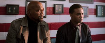 Movie still from “Shaft” (2019), directed by Tim Story – Two men standing next to each other in front of an american flag; Close Up shot, Over the shoulder angle
