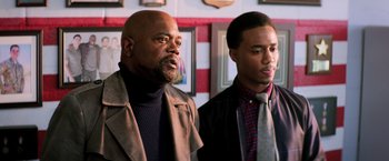 Movie still from “Shaft” (2019), directed by Tim Story – Two men standing next to each other in front of a wall; Medium shot, Over the shoulder angle