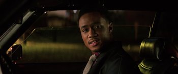 Movie still from “Shaft” (2019), directed by Tim Story – A young man wearing a suit and a tie under an umbrella; Close Up shot, Over the shoulder angle