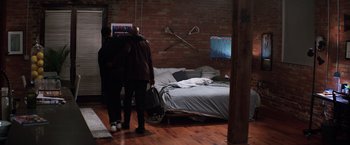 Movie still from “Shaft” (2019), directed by Tim Story – Two people standing in front of a bed in a room; Wide shot, High angle