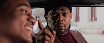 Movie still from “Shaft” (2019), directed by Tim Story – A man in a car with his finger pointed at the camera; Close Up shot, Over the shoulder angle
