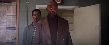 Movie still from “Shaft” (2019), directed by Tim Story – A man in a brown leather jacket standing next to another man in a brown leather jacket; Medium shot, Over the shoulder angle