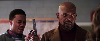 Movie still from “Shaft” (2019), directed by Tim Story – A man holding a gun in his hand and wearing a brown jacket; Close Up shot, Low angle