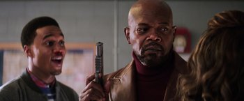 Movie still from “Shaft” (2019), directed by Tim Story – A man holding a gun in his right hand; Close Up shot, Low angle