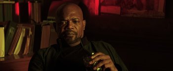 Movie still from “Shaft” (2019), directed by Tim Story – A bald man holding a glass of wine in his hand; Close Up shot, Over the shoulder angle