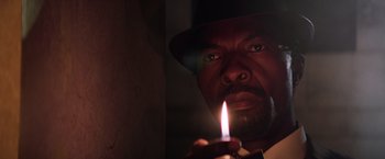 Movie still from “Shaft” (2019), directed by Tim Story – A person holding a lit candle; Extreme Close Up shot, Low angle
