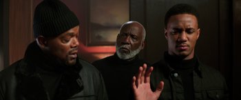 Movie still from “Shaft” (2019), directed by Tim Story – A group of men standing next to each other in a room; Medium shot, Over the shoulder angle