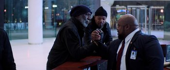 Movie still from “Shaft” (2019), directed by Tim Story – A group of men sitting around a table; Medium shot, Over the shoulder angle