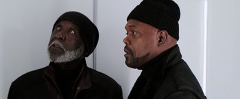 Movie still from “Shaft” (2019), directed by Tim Story – Two men in black jackets and hats looking at each other; Close Up shot, Low angle