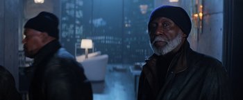 Movie still from “Shaft” (2019), directed by Tim Story – An older man standing in front of a city at night; Medium shot, Over the shoulder angle
