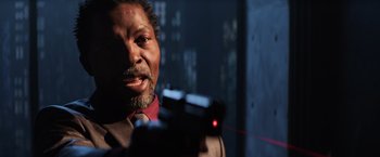 Movie still from “Shaft” (2019), directed by Tim Story – A man in a suit and tie holding a laser gun; Close Up shot, Low angle