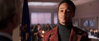 Movie still from “Shaft” (2019), directed by Tim Story – A man in a red jacket standing in front of a group of people; Close Up shot, Over the shoulder angle
