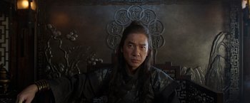 Movie still from “Shang-Chi and the Legend of the Ten Rings” (2021), directed by Destin Daniel Cretton – A man with long black hair wearing a black robe; Close Up shot, Low angle
