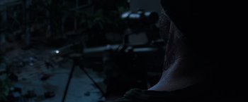 Movie still from “Shang-Chi and the Legend of the Ten Rings” (2021), directed by Destin Daniel Cretton – A person with a tattoo is sitting in a dark room; Extreme Close Up shot, Over the shoulder angle