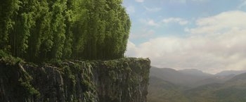 Movie still from “Shang-Chi and the Legend of the Ten Rings” (2021), directed by Destin Daniel Cretton – A tree growing on top of a cliff in front of a mountain range; Extreme Wide shot, Low angle
