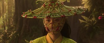 Movie still from “Shang-Chi and the Legend of the Ten Rings” (2021), directed by Destin Daniel Cretton – A woman wearing a mask and a straw hat; Close Up shot, Low angle