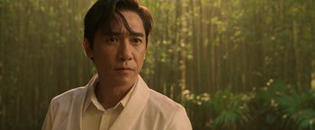 Movie still from “Shang-Chi and the Legend of the Ten Rings” (2021), directed by Destin Daniel Cretton – A person wearing a white shirt; Close Up shot, Over the shoulder angle