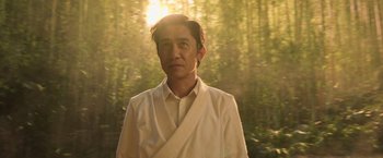 Movie still from “Shang-Chi and the Legend of the Ten Rings” (2021), directed by Destin Daniel Cretton – A man wearing a white shirt and a white tie; Close Up shot, Low angle