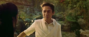 Movie still from “Shang-Chi and the Legend of the Ten Rings” (2021), directed by Destin Daniel Cretton – A man wearing a white shirt and a white jacket; Medium shot, Low angle