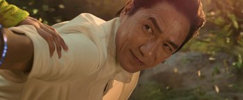 Movie still from “Shang-Chi and the Legend of the Ten Rings” (2021), directed by Destin Daniel Cretton – A person wearing a white shirt; Close Up shot, Low angle
