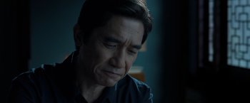 Movie still from “Shang-Chi and the Legend of the Ten Rings” (2021), directed by Destin Daniel Cretton – A person sitting in a room near a window; Close Up shot, Over the shoulder angle