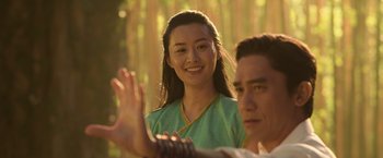 Movie still from “Shang-Chi and the Legend of the Ten Rings” (2021), directed by Destin Daniel Cretton – A young woman and a young man are smiling; Medium shot, Over the shoulder angle