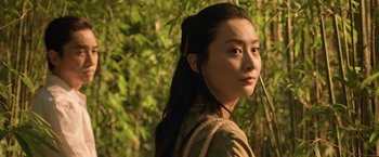 Movie still from “Shang-Chi and the Legend of the Ten Rings” (2021), directed by Destin Daniel Cretton – A woman with long black hair standing in front of a tree; Close Up shot, Low angle
