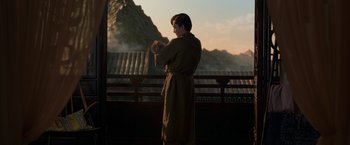 Movie still from “Shang-Chi and the Legend of the Ten Rings” (2021), directed by Destin Daniel Cretton – A man in a robe stands in front of a mountain; Medium shot, Over the shoulder angle