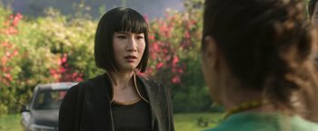 Movie still from “Shang-Chi and the Legend of the Ten Rings” (2021), directed by Destin Daniel Cretton – A woman in a black jacket is talking to another woman; Close Up shot, Over the shoulder angle