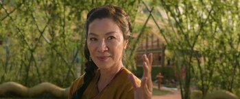 Movie still from “Shang-Chi and the Legend of the Ten Rings” (2021), directed by Destin Daniel Cretton – An older woman giving the peace sign with her hand; Close Up shot, Low angle