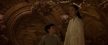 Movie still from “Shang-Chi and the Legend of the Ten Rings” (2021), directed by Destin Daniel Cretton – A woman and a boy standing next to each other; Medium shot, Low angle