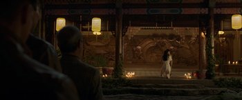 Movie still from “Shang-Chi and the Legend of the Ten Rings” (2021), directed by Destin Daniel Cretton – A man and a woman walking in front of a building at night; Extreme Wide shot, Over the shoulder angle