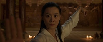 Movie still from “Shang-Chi and the Legend of the Ten Rings” (2021), directed by Destin Daniel Cretton – A woman in a white shirt is holding a sword; Close Up shot, Low angle