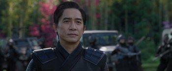 Movie still from “Shang-Chi and the Legend of the Ten Rings” (2021), directed by Destin Daniel Cretton – A person wearing a uniform; Close Up shot, Over the shoulder angle