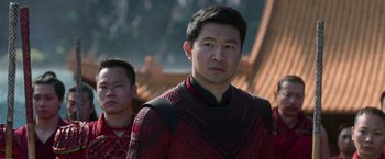 Movie still from “Shang-Chi and the Legend of the Ten Rings” (2021), directed by Destin Daniel Cretton – A man in a red and black outfit standing next to another man in a red and black outfit; Medium shot, Over the shoulder angle