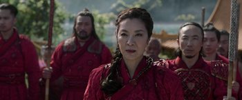 Movie still from “Shang-Chi and the Legend of the Ten Rings” (2021), directed by Destin Daniel Cretton – A woman in a red dress with two men in red robes; Close Up shot, Over the shoulder angle
