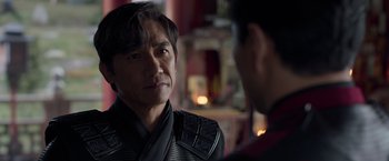 Movie still from “Shang-Chi and the Legend of the Ten Rings” (2021), directed by Destin Daniel Cretton – A man wearing a black leather jacket talking to another man wearing a black leather jacket; Close Up shot, Over the shoulder angle