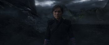 Movie still from “Shang-Chi and the Legend of the Ten Rings” (2021), directed by Destin Daniel Cretton – A man in a black jacket standing in front of a mountain; Medium shot, Over the shoulder angle