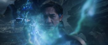 Movie still from “Shang-Chi and the Legend of the Ten Rings” (2021), directed by Destin Daniel Cretton – A person wearing a suit and tie; Close Up shot, Over the shoulder angle