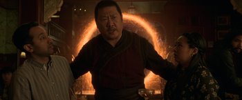 Movie still from “Shang-Chi and the Legend of the Ten Rings” (2021), directed by Destin Daniel Cretton – An asian man in front of an orange light; Medium shot, Over the shoulder angle