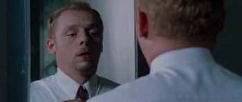 Movie still from “Shaun of the Dead” (2004), directed by Edgar Wright – A man looking at himself in the mirror; Close Up shot, Over the shoulder angle