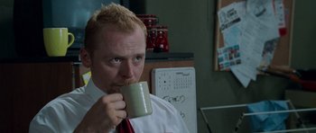 Movie still from “Shaun of the Dead” (2004), directed by Edgar Wright – A man in a white shirt and red tie holding a mug; Close Up shot, Low angle